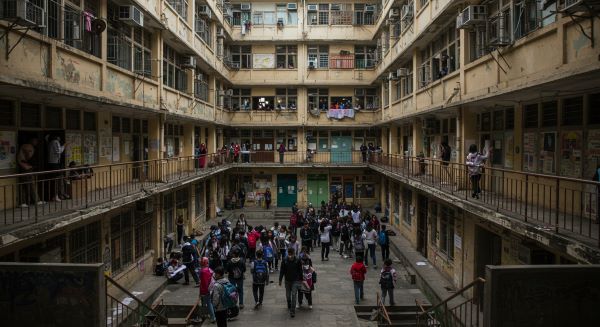An old school building with a crowd of students.