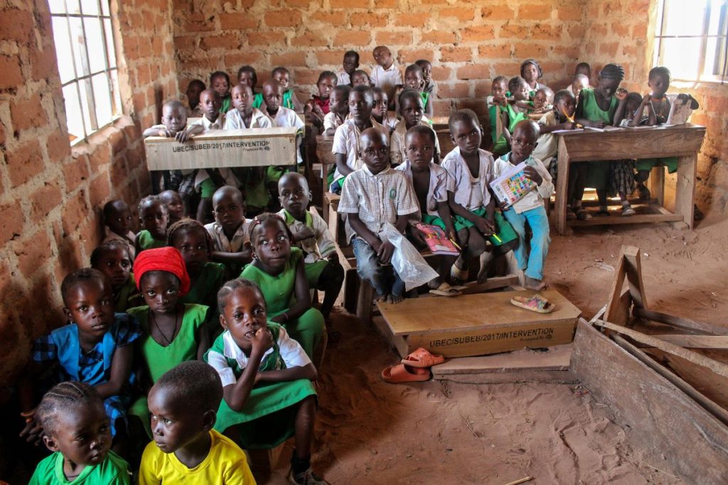 Children inside a classroom with a lack of facilities.